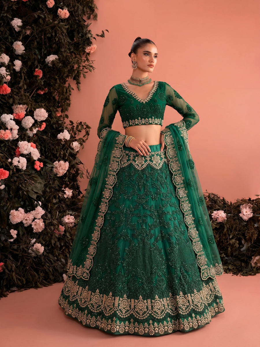 Woman wearing emerald embroidered net lehenga set with sheer dupatta and intricate bridal embroidery