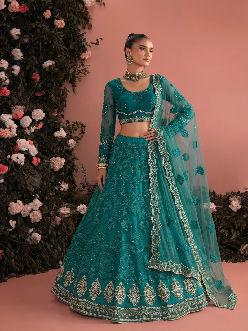 Woman wearing teal embroidered net lehenga set with sheer dupatta and detailed bridal embroidery