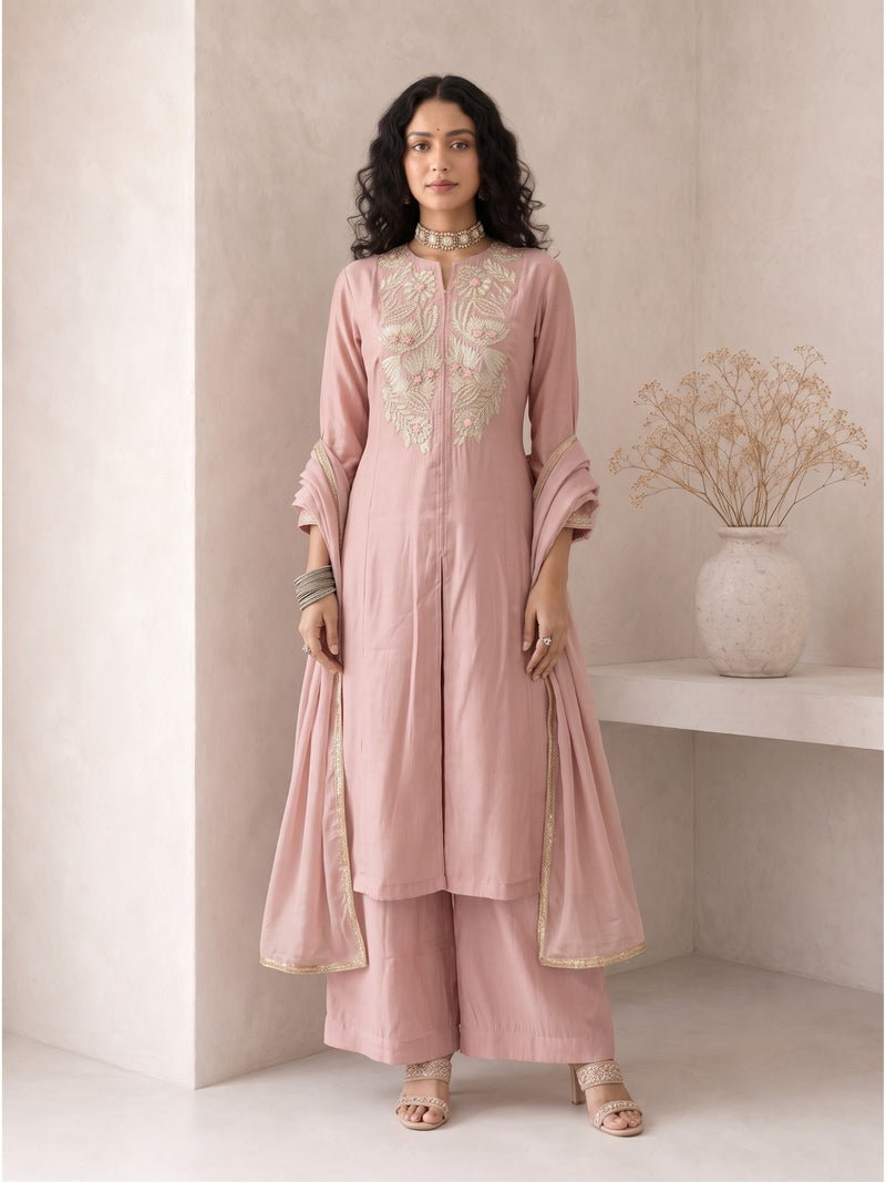 Woman wearing Roselle Blush Roman Silk Anarkali Suit Set with embroidered neckline, matching pants and organza dupatta for Raksha Bandhan and festive occasions.