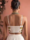 Back view of ivory lehenga blouse with adjustable straps, smocked panel and floral bead embroidery