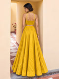 Back view of yellow lehenga set showing smocked choli panel, halter straps and flowing full-length skirt