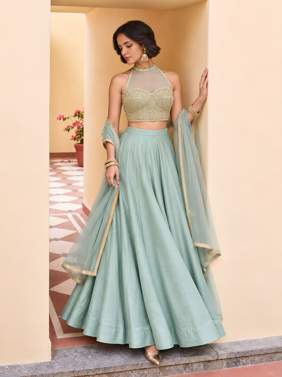 Mint green embellished lehenga styled with sheer net dupatta and detailed border for a wedding celebration