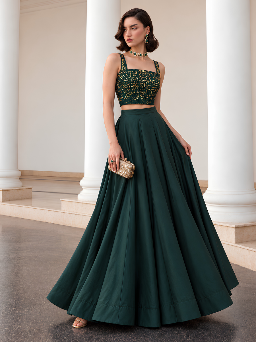 Deep emerald green lehenga with gold-detailed choli and flowing full-length skirt