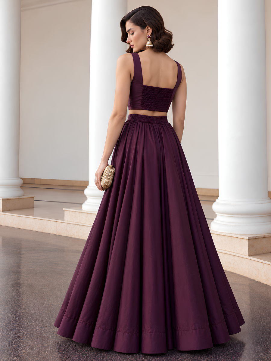 Back view of the deep plum lehenga set showing the smocked choli panel and full-length skirt