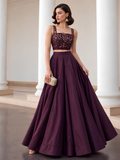 Deep plum lehenga set with gold-detailed choli, showing the skirt's wide flare and flowing folds