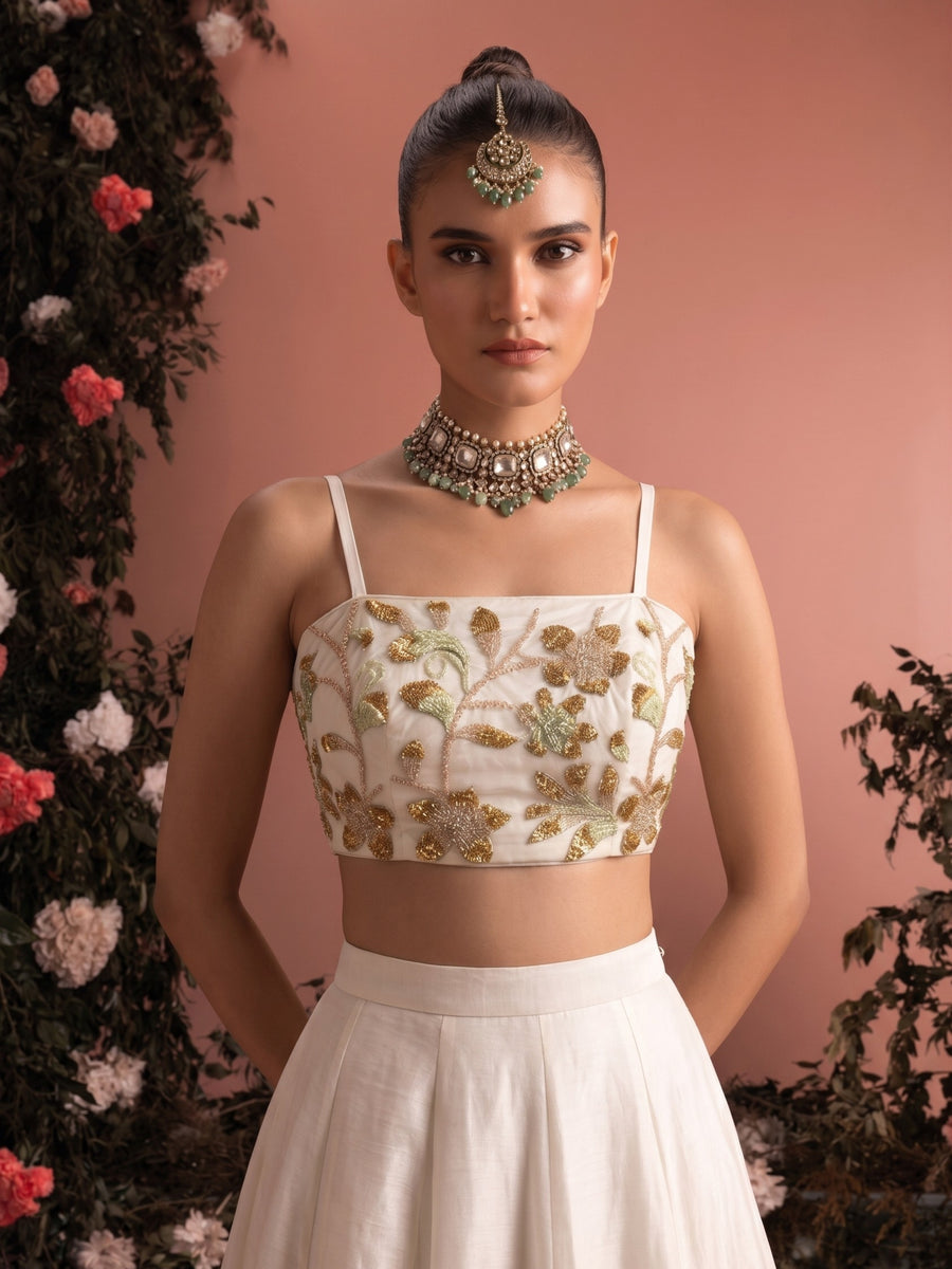 Close-up of ivory lehenga blouse showing intricate floral bead embroidery